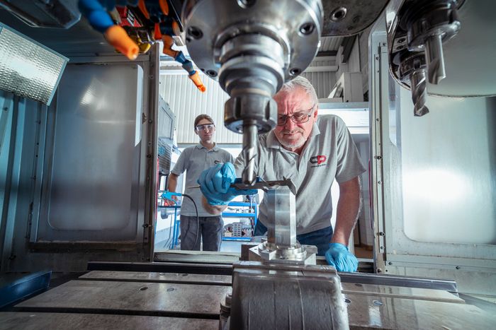 CNC machinist operating a milling machine at Clarent Precision