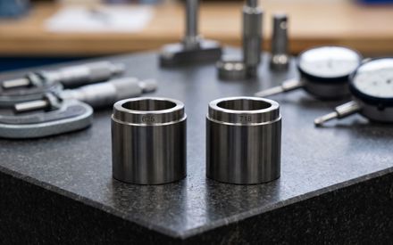 Two CNC machined nickel superalloy components marked 625 and 718 side by side on a granite inspection plate
